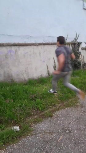 Man climbs over ivy-covered wall in Svishtov, Bulgaria