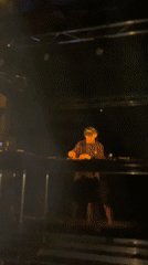 DJ performs under laser lights at outdoor night event