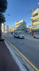 Tree-lined street panned under blue skies in Icheon-si