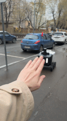 Moscow resident greets delivery robot on wet street