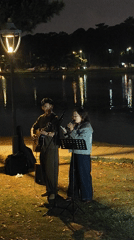 Street musicians perform by waterfront in Da Lat Vietnam