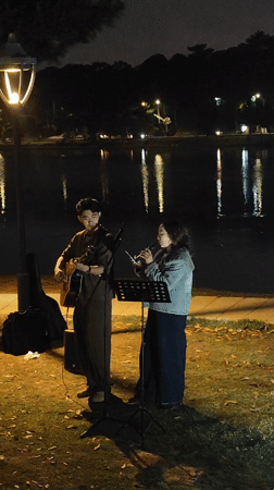 Street musicians perform by waterfront in Da Lat Vietnam