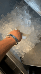 Person transfers ice cubes with scoop in Essen