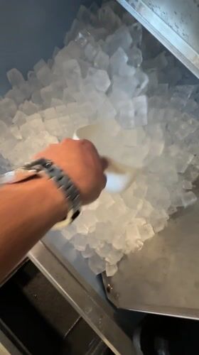 Person transfers ice cubes with scoop in Essen