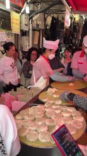 Seoul market vendors serve dumplings to early morning customers