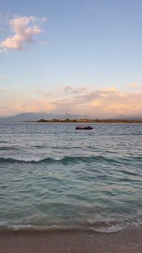 Beach, market stalls, and local life along an Indonesian shore