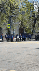 Fire truck passes military band near crosswalk in Rusanovo