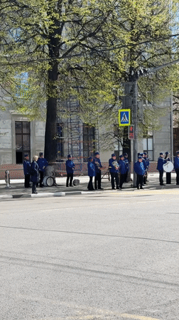 Fire truck passes military band near crosswalk in Rusanovo