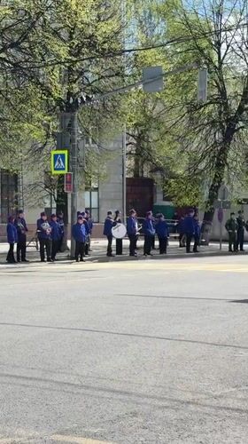 Fire truck passes military band near crosswalk in Rusanovo