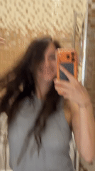 Bathroom mirror selfie with orange phone case