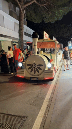 Novelty tourist train parked on a Gatteo street at night
