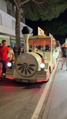 Novelty tourist train parked on a Gatteo street at night