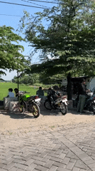 Rural Indonesian village life with motorcycles and rice fields