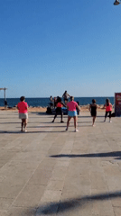 Kitesurfers and beachgoers fill a sunny Quarteira afternoon
