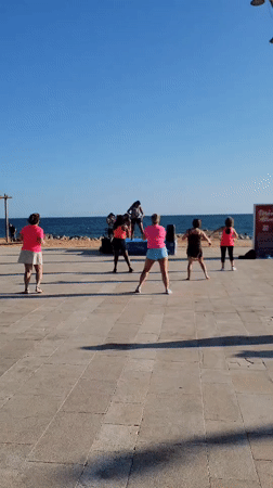 Kitesurfers and beachgoers fill a sunny Quarteira afternoon