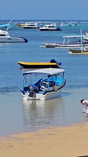 Sanur Beach in full morning swing — water, wheels, and shoreline life