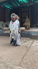 Fire-breathing performer in layered costume entertains audience in Accra
