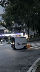 Autonomous cleaning robots sweep Jiangjin streets at dusk