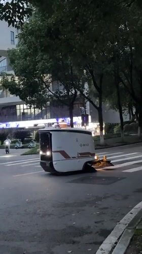 Autonomous cleaning robots sweep Jiangjin streets at dusk