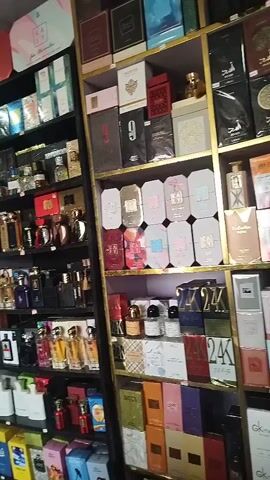 This video shows a retail store that appears to sell perfume and cosmetics. The store has numerous shelves stocked with a wide variety of perfume bottles and boxes, arranged by color and brand. The shelves are well-lit, and the overall impression is one of abundance and variety. The video pans across the shelves, showcasing the extensive collection of products. The store appears clean and organized, with products neatly displayed. There are no people visible in the video.