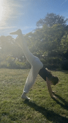 Woman performs gymnastics in sunny residential garden setting