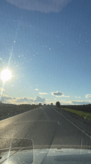 Vehicle travels rural road in sunny Russia