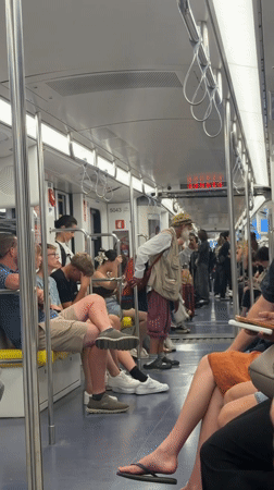 Colorfully dressed passenger stands in a Milan train car