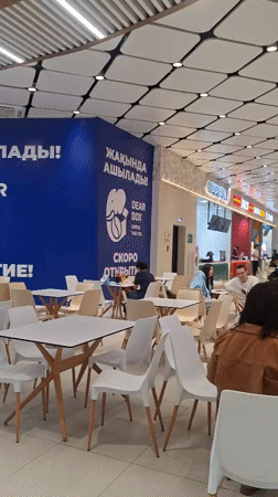 Rainy day inside a Kokshetau mall, mosque visible outside