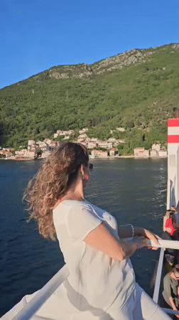 Woman enjoys boat trip in Montenegro's scenic bay