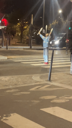 Street juggler performs on Paris crosswalk Sunday night