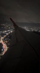AirAsia flight observed over illuminated Kuta cityscape at night