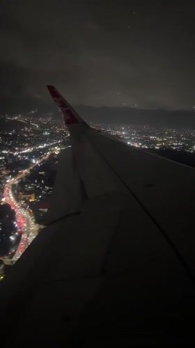 AirAsia flight observed over illuminated Kuta cityscape at night