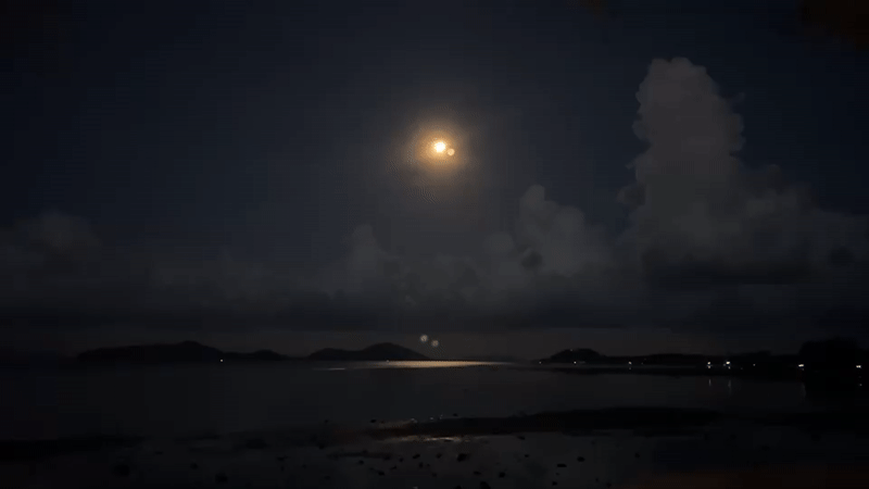 Full moon illuminates Thai coastal waters during nighttime scene