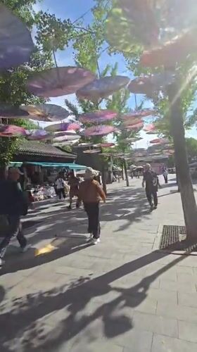 Huairou street market under a canopy of colorful hanging umbrellas