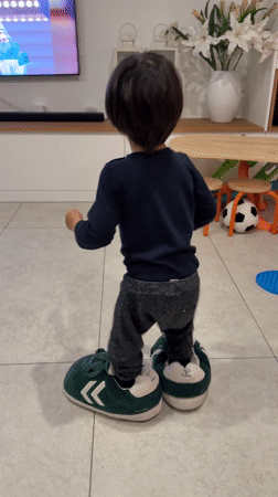 Toddler in oversized slippers captured at Luxembourg home