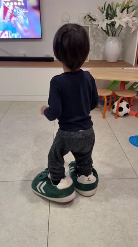 Toddler in oversized slippers captured at Luxembourg home