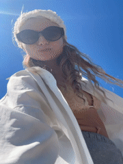 Woman enjoys beach day with selfies and picnic