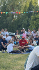 Community festival with traditional performances and games on grassy field