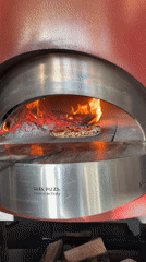 Pizza bakes in wood-fired oven in Tivat, Montenegro