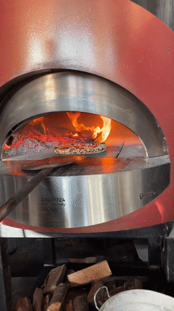Pizza bakes in wood-fired oven in Tivat, Montenegro