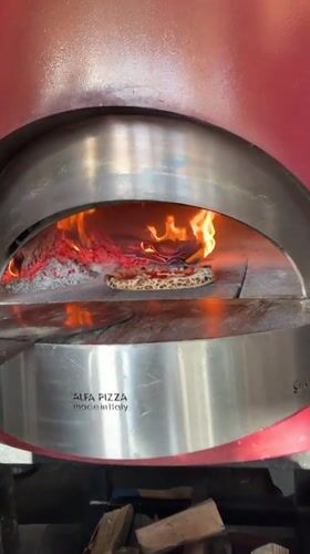 Pizza bakes in wood-fired oven in Tivat, Montenegro