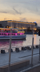 Evening riverboat cruise passes illuminated Moscow waterfront at dusk