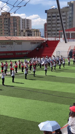Youth marching band performs on sports field in La Paz