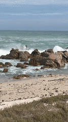 Tourist explores Cape Agulhas lighthouse and dramatic coastline