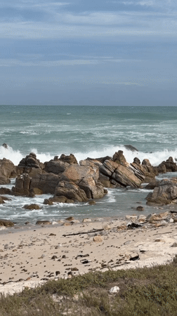 Tourist explores Cape Agulhas lighthouse and dramatic coastline