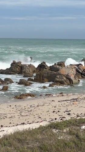 Tourist explores Cape Agulhas lighthouse and dramatic coastline