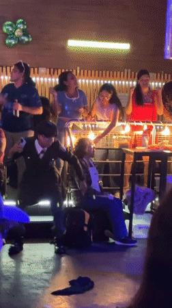 Nightclub patrons dance under colorful lights in Lima