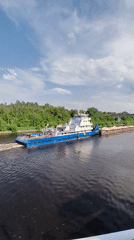 Tugboat OT-2060 tows cargo barge through Yakhroma River