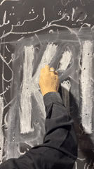 Chalk writing in Farsi and English on a black surface in Tehran