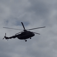 Military-style helicopter in flight over cloudy Russian skies